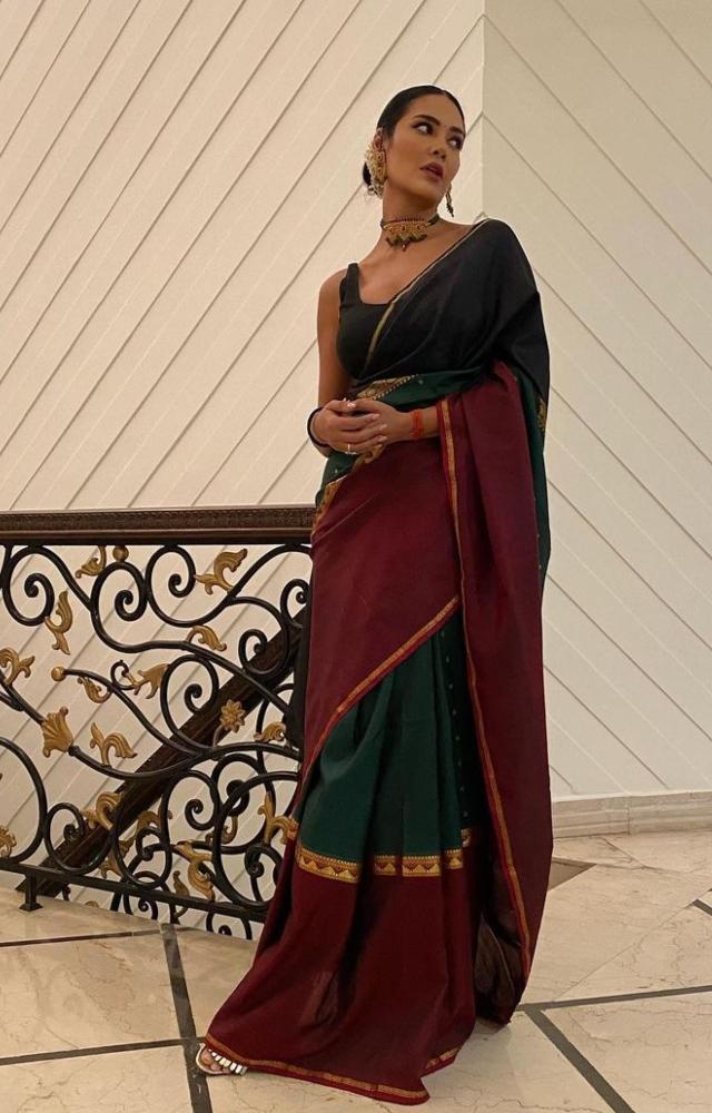 Esha Gupta gave an outfit inspiration for the upcoming festive season. She wore a dark green and red saree with golden embroidery